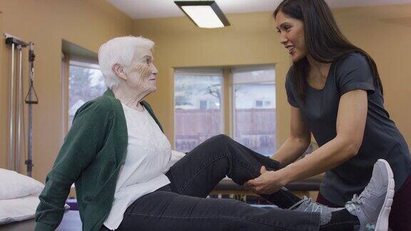 理疗师按摩老年女性的小腿肌肉