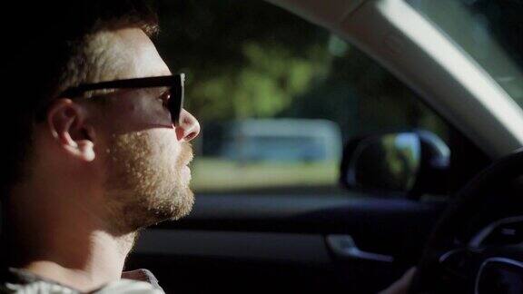 一个男人开着一辆现代汽车一个留着胡子戴着太阳防护眼镜的英俊男子自信地驾驶