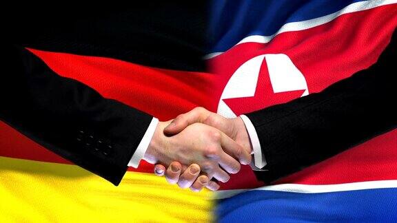 德国代表和朝鲜代表握手 国旗背景