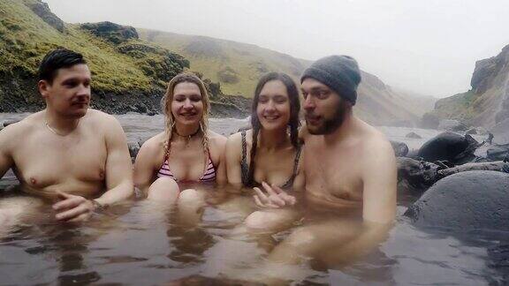 冰岛的地热温泉两对旅游夫妇在冰岛的温泉池里放松游客享受洗澡