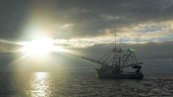 捕虾船在日出时用网捕鱼