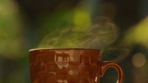 4k热腾腾的蒸意式咖啡特写棕色茶杯与阳光背景热饮概念