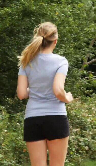 在公园里跑步的女人后视图垂直跟踪镜头
