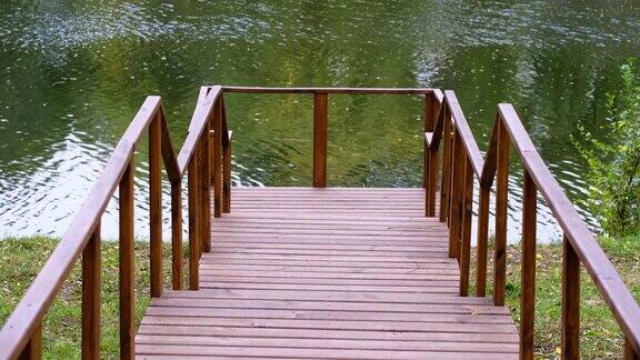木制的空码头与栏杆在流动的河流背景在美丽平静的夏日宁静没有人