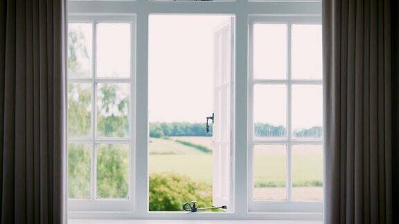 卧室窗帘打开透过窗户展现乡村风貌