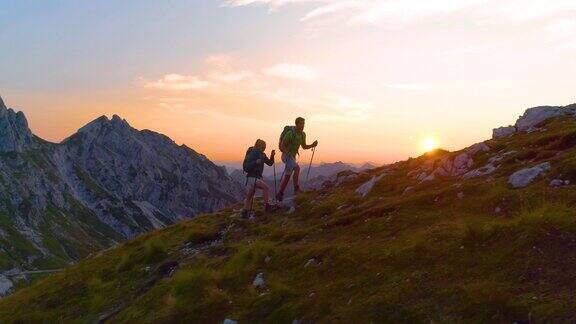 日落时分年轻游客们在阿尔卑斯山徒步旅行