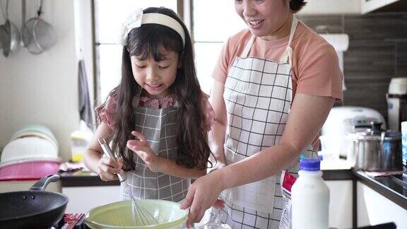 妈妈和女儿在厨房里做煎饼