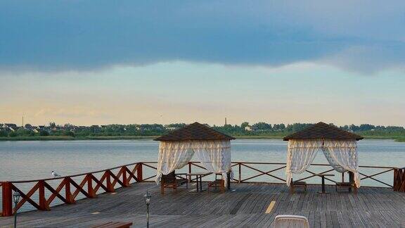 白俄罗斯维捷布斯克Voblast的布拉斯劳木凉亭与桌子和长凳在一个木制码头钓鱼和休息附近和美丽的诺瓦提湖布拉斯拉夫湖上的度假村