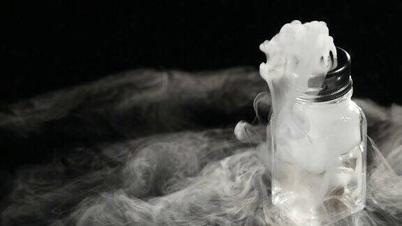 抽象的白烟在玻璃中干冰对黑暗背景的影响