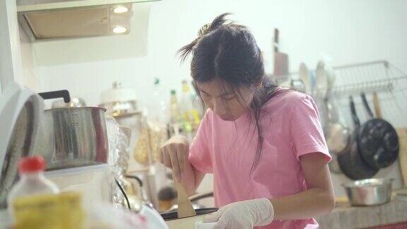 亚洲女孩在家厨房里自己做饭生活理念