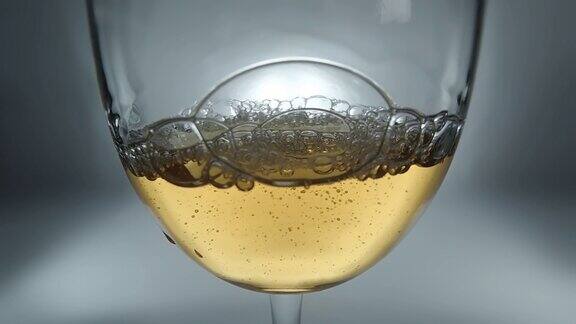 创意宏慢动作4k视频白葡萄酒倒入杯子玻璃与倒白葡萄酒与飞溅和泡沫的特写
