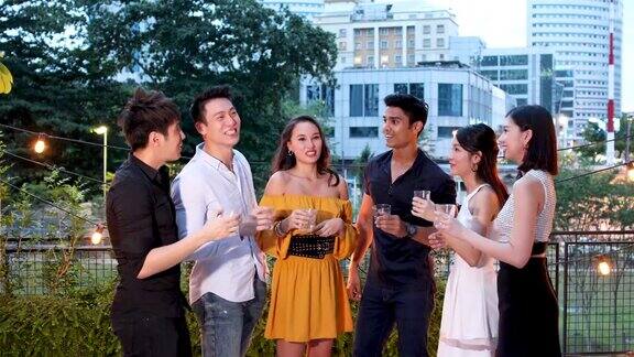 亚洲朋友在屋顶派对上享受饮料和食物