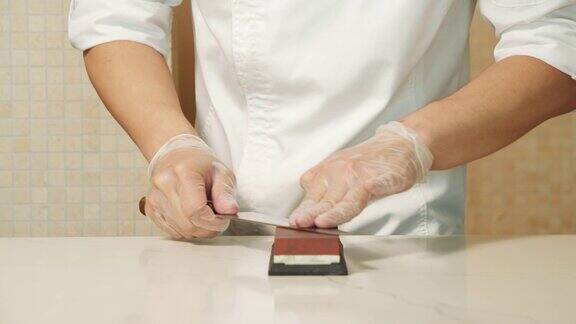 厨师用手磨刀的慢动作特写男子的双手准备专业工具烹饪食物在厨房餐厅