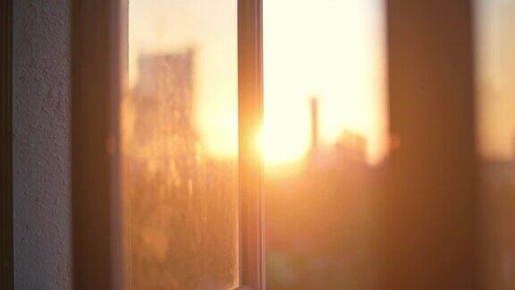 日落美景模糊从家庭房间窗口到城市景观
