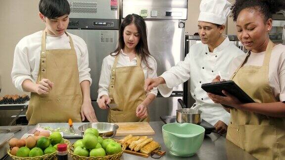 在烹饪课程中厨师教年轻的烹饪学生削水果皮