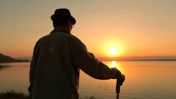 快乐时光老亚男在湖边欣赏日落慢镜头