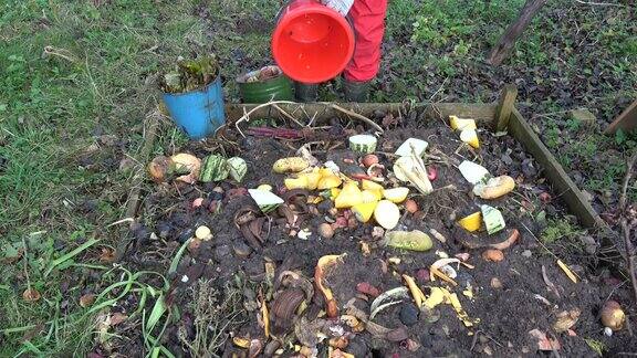 园丁把蔬菜和水果废料倒在堆肥堆里