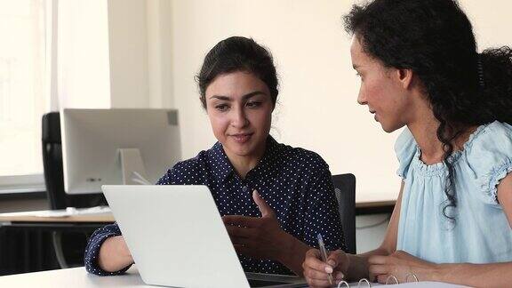 多种族的女性同事使用笔记本电脑一起工作的项目