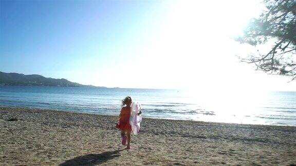 小女孩穿过海滩奔向大海