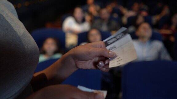 在电影院门口将电影票递给工作人员的不认识的顾客