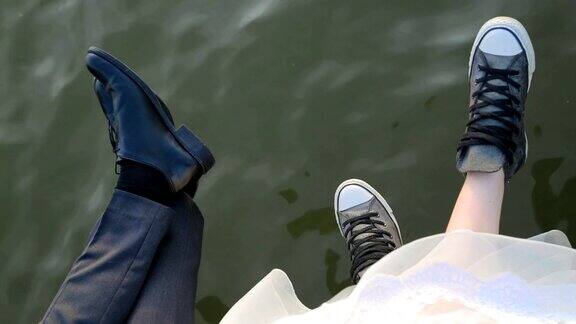 一对夫妇的腿坐在码头上