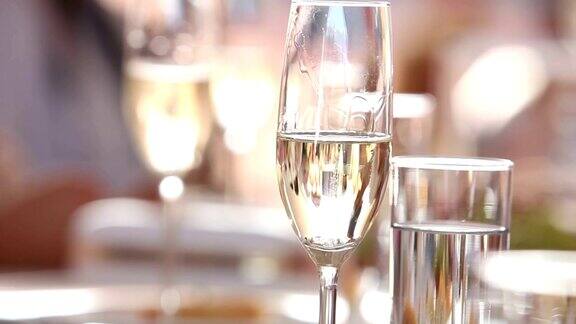服务员倒香槟在葡萄酒杯在一个餐厅服务员倒香槟在水晶玻璃杯餐厅内部自助餐桌服务员在白手套特写