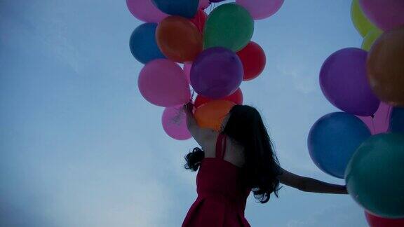 女孩拿着气球以天空为背景的慢镜头