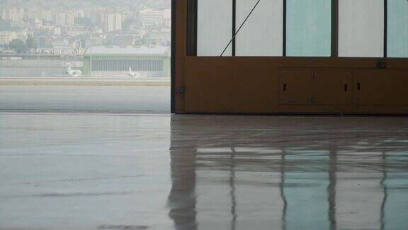 机场降落场附近的环氧地坪上巨大的机库门带大玻璃窗缓慢关闭