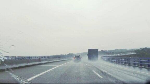 在高速公路上下雨时从汽车挡风玻璃拍摄的驾驶视图