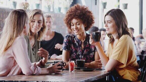 一群女性朋友聚在一起围坐在桌边聊天用慢镜头拍摄