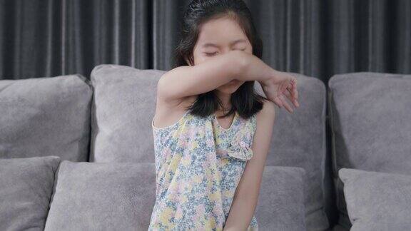亚洲小孩打喷嚏用餐巾擤鼻子她过敏年轻女孩感冒在家