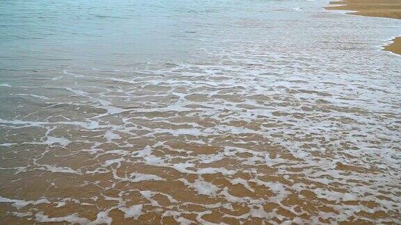 沙滩上的新脚印被海浪冲走了