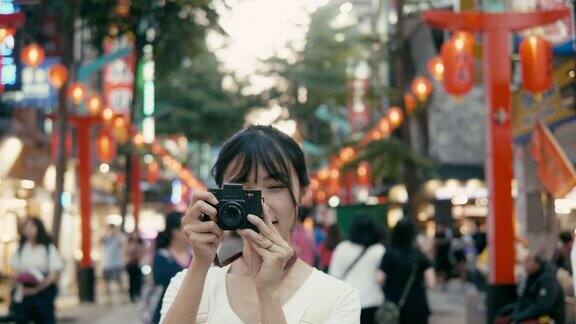 台湾千禧一代女性在西门町购物区用复古相机拍照(慢镜头)