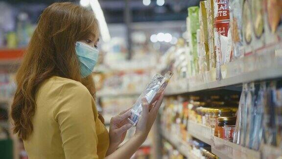年轻女子戴着口罩在超市买食物