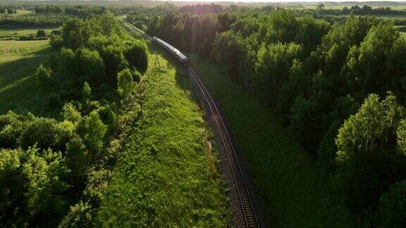 火车上的旅客在日落时分从森林出发鸟瞰