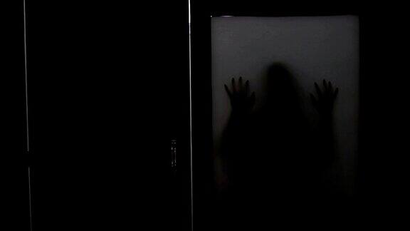 哑光玻璃窗后面幽灵女人的阴森剪影
