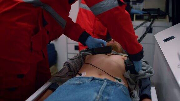 急救医生在救护车上对病人使用心脏除颤器