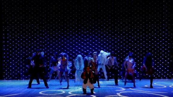 艺术家们穿着华丽的服装涂着油彩在剧院的舞台上跳舞