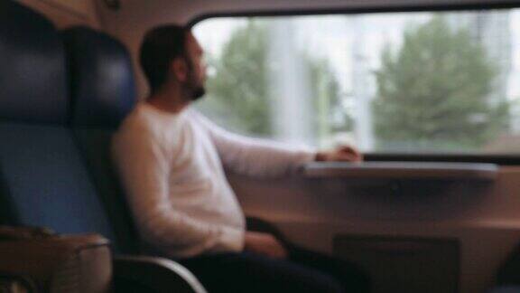 火车上一个沉思的男人的肖像看着窗外失去了焦点