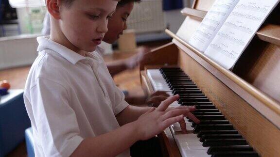 两个男生在音乐课上一起弹钢琴