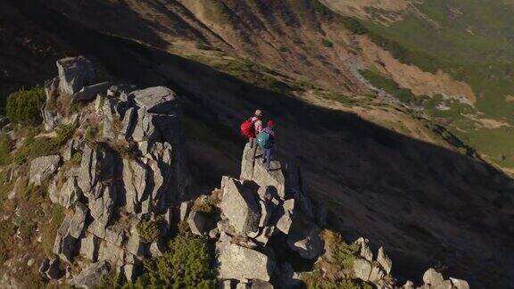 鸟瞰图的徒步旅行者夫妇与背包山顶的游客