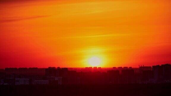 夕阳在红色的天空与晚霞在城市时间流逝落日照耀着高楼林立的城市