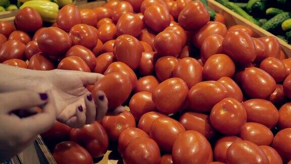 一位年轻女子在杂货店里检查西红柿