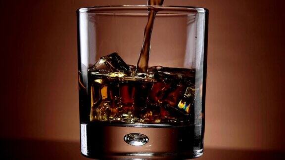 倒威士忌在一个玻璃杯与冰-美丽的慢镜头