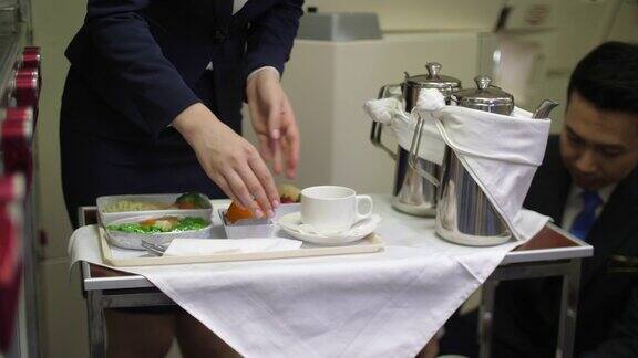 空中小姐为商务旅行准备和提供美味的食品和茶