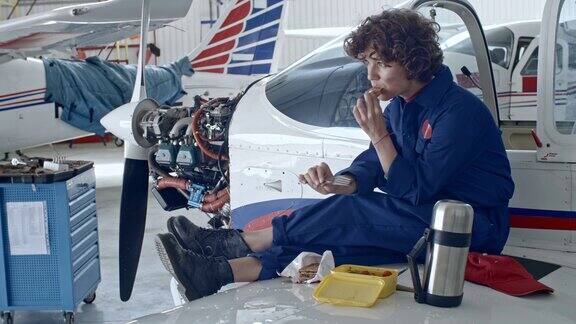 女飞机技术员在机库吃午餐