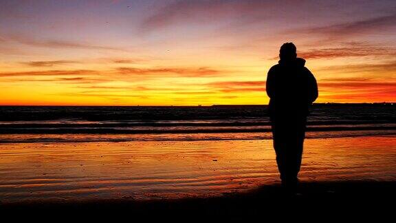 海滩上日落前男人的剪影