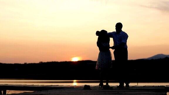 一对年轻的情侣在夕阳下跳舞