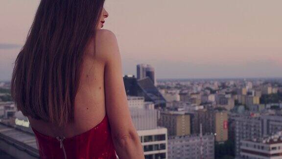 屋顶上的诱惑女人穿着漂亮的红色裙子用摄影机调情