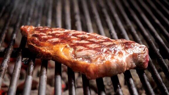 烧烤时炸牛排典型的阿根廷烤肉在烤架上烧木头和烧红的煤